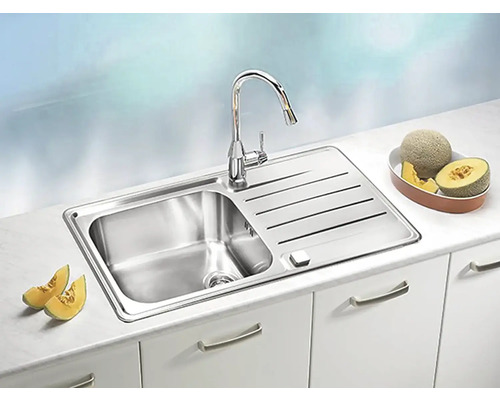 Nerezový drez s odkvapkávacou plochou a batériou na kuchynskej linke