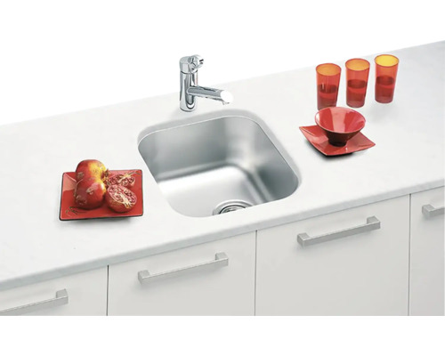Nerezový kuchynský drez s vodovodnou batériou na kuchynskej linke s riadom