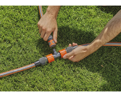 Zavlažovacia scéna záhrady s T-kusom a hadicovými spojkami na trávniku