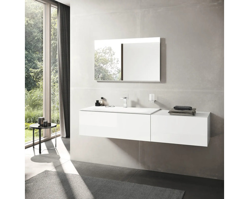 Moderná kúpeľňa s bielou umývadlovou skrinkou, zrkadlom a oknom pre svetlú atmosféru