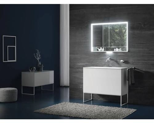 Svetlá kúpeľňa s umývadlom, osvetlenou zrkadlovou skrinkou a kúpeľňovým kobercom