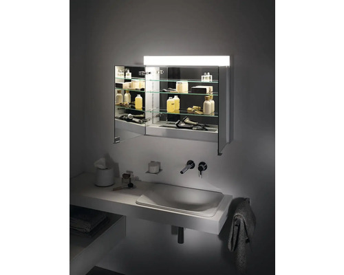 Moderná kúpeľňa so zrkadlovou skrinkou, umývadlom a doplnkami.