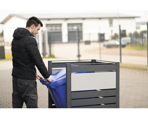 Muž zasúva modrú smetnú nádobu do šedého boxu na smetné nádoby