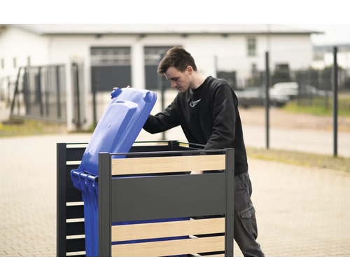 Box na odpadkové koše s osobou, ktorá doň vkladá modrý kontajner na odpad