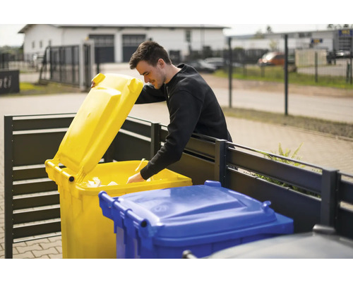 Muž hádže papier do žltej smetnej nádoby