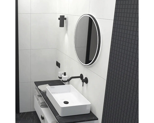 Svetlá kúpeľňa s umývadlom, zrkadlom a čiernymi akcentmi pre elegantný dizajn.