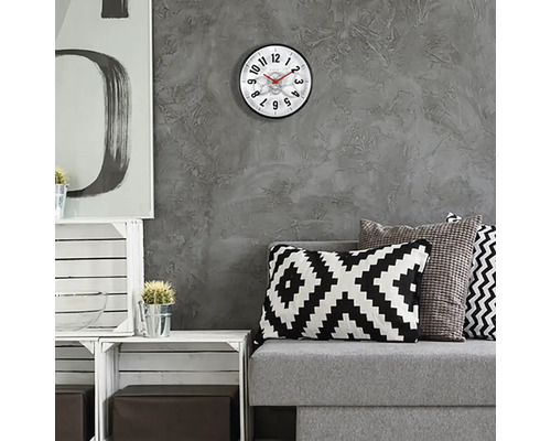 Obývacia izba s nástennými hodinami, pohovkou a dekoratívnymi prvkami