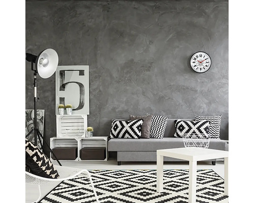 Obývacia izba s pohovkou, stolom, kobercom a dekoráciou v čiernej, bielej a sivej farbe