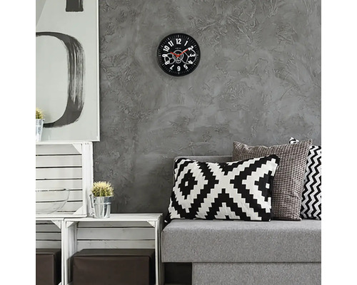 Obývacia izba so sivou pohovkou, vankúšmi a nástennými hodinami s viditeľným mechanizmom