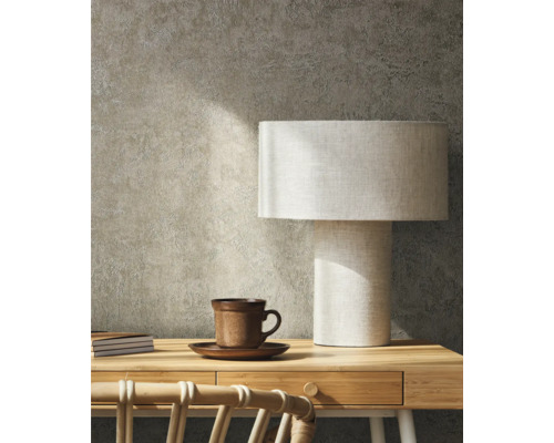 Scéna s písacím stolom, stolnou lampou, šálkou a zápisníkmi na pozadí textúrovanej steny