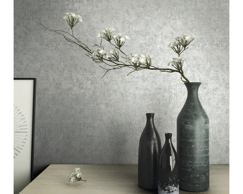 Dekoratívne zátišie s vázami a umelými kvetmi na stole.