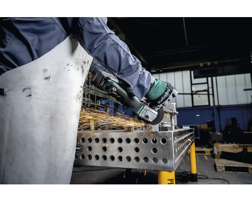 Osoba brúsi kov pomocou uhlovej brúsky Metabo