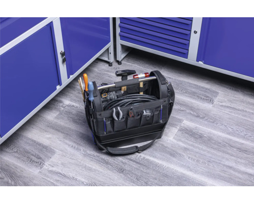 Taška na náradie s náradím pred modrými dielenskými skriňami