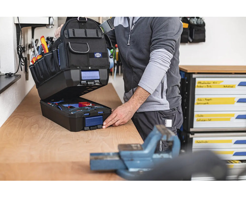 Otvorená taška na náradie s náradím na pracovnom stole