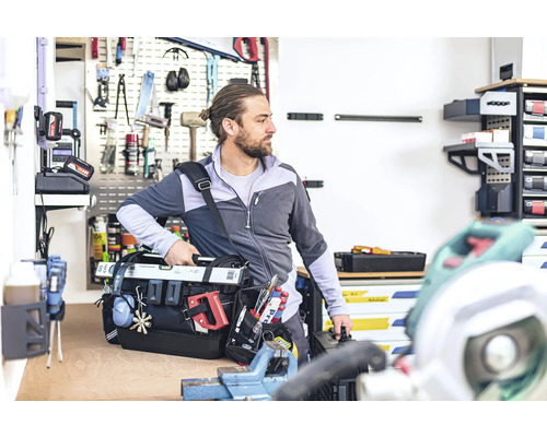 Remeselník s brašňou na náradie v dielni