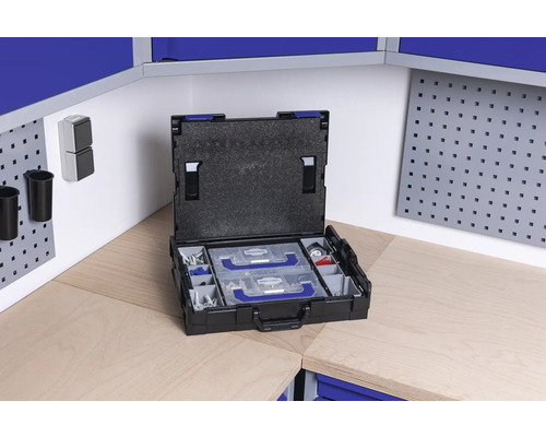 Otvorený kufrík na náradie s vložkami na pracovnom stole