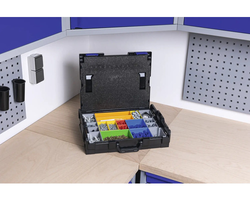 Otvorený sortimentný box s rôznymi skrutkami a drobnými dielmi na pracovnom stole