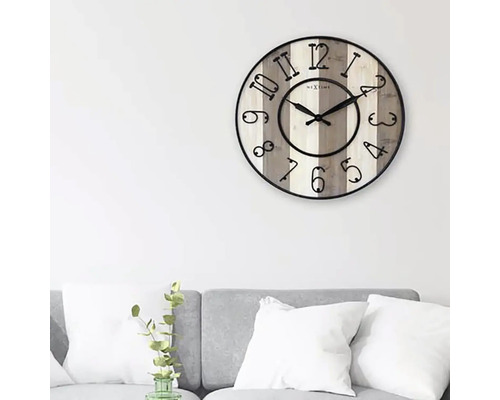 Nástenné hodiny Nextime s číslicami na svetlom drevenom pozadí