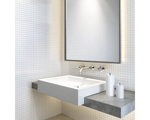 Moderná kúpeľňa s bielym umývadlom na dosku, zrkadlom a batériou