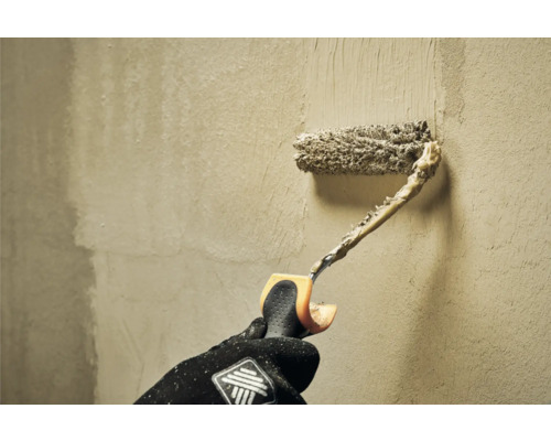 Osoba valcuje stenu valčekom na maľovanie.