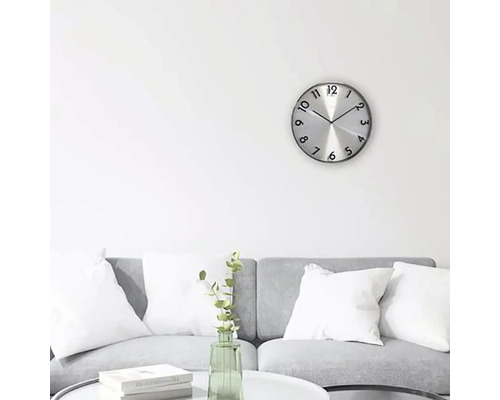 Obývacia izba so sivou pohovkou, konferenčným stolíkom a okrúhlymi nástennými hodinami