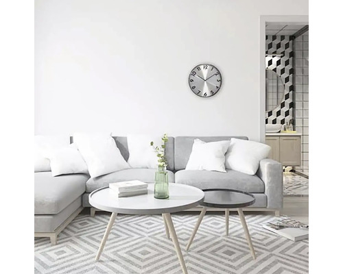 Svetlá obývacia izba so sivou pohovkou, konferenčnými stolíkmi a nástennými hodinami