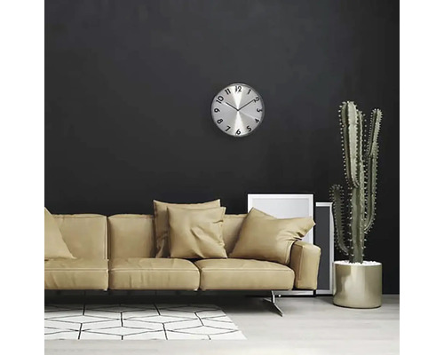 Obývacia izba s pohovkou, nástennými hodinami a kaktusom