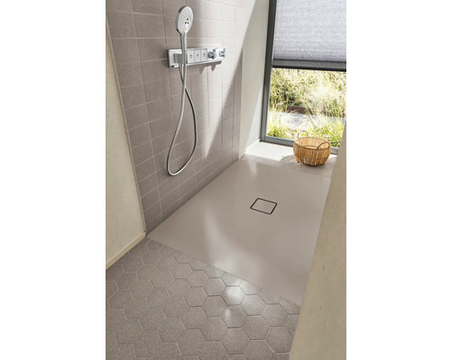 Sprchovací kút v úrovni podlahy so sprchovou hlavicou, sprchovacou vaničkou a šesťhrannými dlaždicami