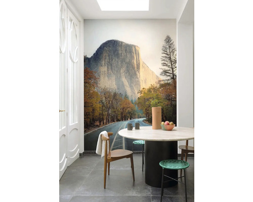 Svetlá kuchyňa s fototapetou horského masívu, jedálenskou súpravou a sivou podlahovou dlažbou.