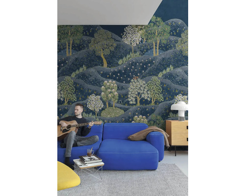 Obývacia izba s modrou pohovkou, konferenčným stolíkom a nástennou tapetou s motívom lesa