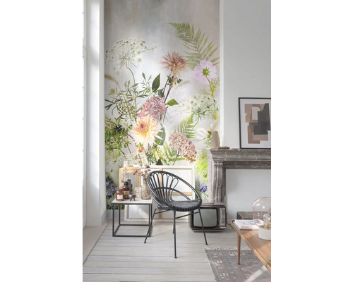 Obývacia izba s kvetinovou tapetou, ratanovým kreslom, odkladacím stolíkom a dekoráciou