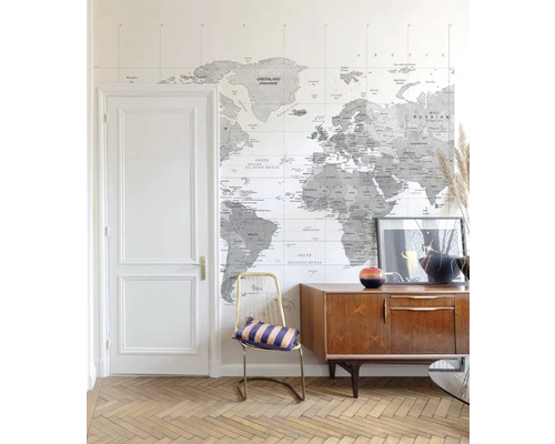 Svetlá miestnosť s mapou sveta ako tapetou, komodou a stoličkou