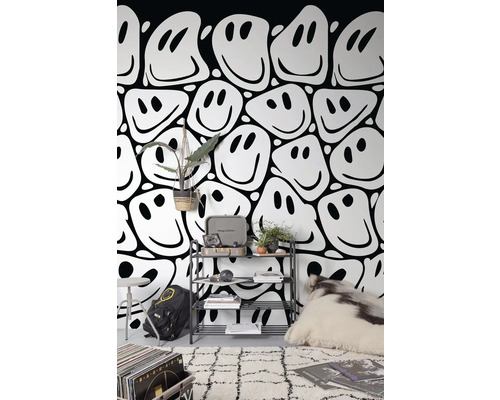 Obývacia izba s tapetou so vzorom smajlíkov, regálom, kobercom a dekoratívnymi prvkami