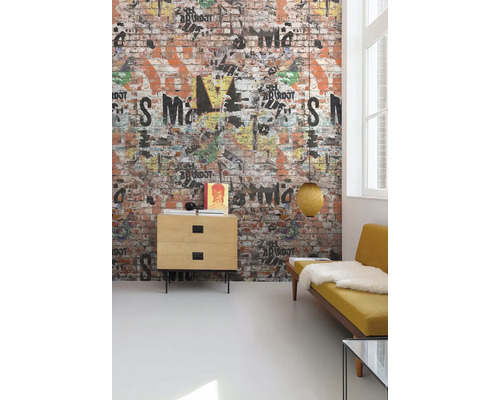 Obývacia izba s tapetou na stene s dizajnom tehlovej steny, zdobenou graffiti, komoda, lampa a žltá pohovka.