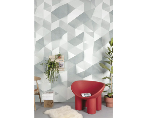 Obývacia izba s geometrickou tapetou, červeným kreslom a rastlinami