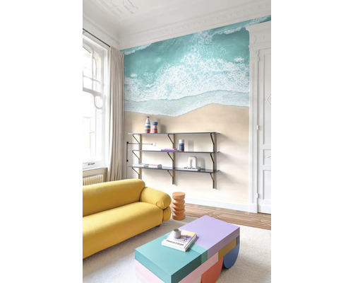 Obývacia izba s pohovkou, policou a nástennou maľbou s plážovým motívom
