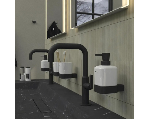 Moderná kúpeľňa s čiernym mramorovým umývadlom, batériami, dávkovačom mydla a osvetleným zrkadlom