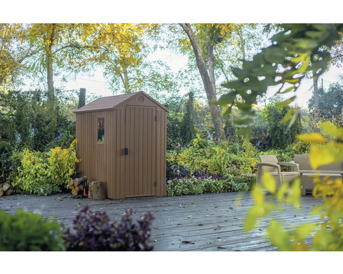 Plastový záhradný domček s oknom a dverami na terase v záhrade.