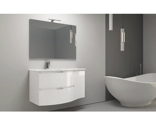 Kúpeľňa s umývadlovou skrinkou, zrkadlom, lampou a vaňou.