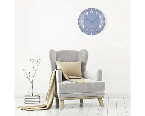 Obývacia izba s kreslom a modrými nástennými hodinami