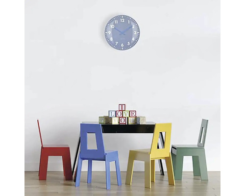 Scéna so stolom, štyrmi stoličkami a nástennými hodinami