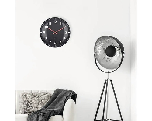 Obývacia izba s nástennými hodinami, stojacou lampou a pohovkou