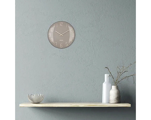 Nástenné hodiny s ciferníkom na poličke s dekoráciami
