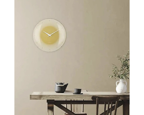 Nástenné hodiny v obývacej izbe nad stolom s čajovou kanvicou a vázou