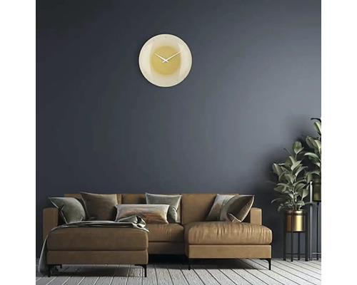 Obývacia izba s pohovkou, izbovou rastlinou a okrúhlymi nástennými hodinami