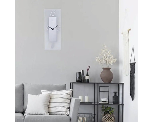 Obývacia izba s pohovkou, regálom a obdĺžnikovými nástennými hodinami s číslicami