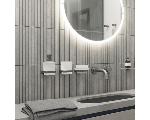 Moderná kúpeľňa s okrúhlym zrkadlom, umývadlom, batériou a kúpeľňovými doplnkami