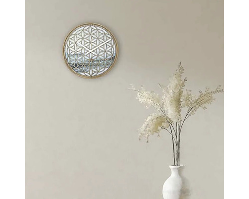 Dekoratívne nástenné hodiny s geometrickým vzorom a biele okrasné trávy vo váze