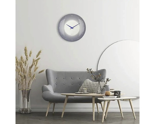 Obývacia izba so sivou pohovkou, drevenými stolíkmi a okrúhlymi nástennými hodinami
