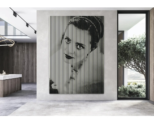 Obývacia izba s nástennou dekoráciou zobrazujúcou tvár ženy vo zvislých líniách.